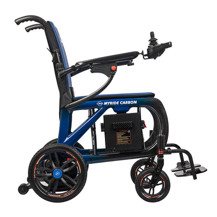 A MYTRIDE Carbon electric folding wheelchair shown from a side profile view against a solid white background. The wheelchair features a dark blue and black frame with a carbon fiber pattern, black wheels, and a joystick control on the right side.